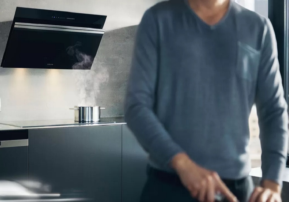 Siemens liesituulettimet Henkilö laittamassa ruokaa, taka-alalla näkyy Siemens liesituuletin